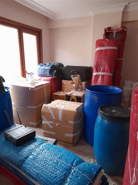 Taşınma öncesi odada paketlenmiş eşyalar ve koliler.