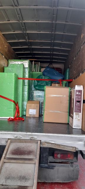 Kamyon kasasında paketlenmiş eşyalar ve sabitleme kayışları.